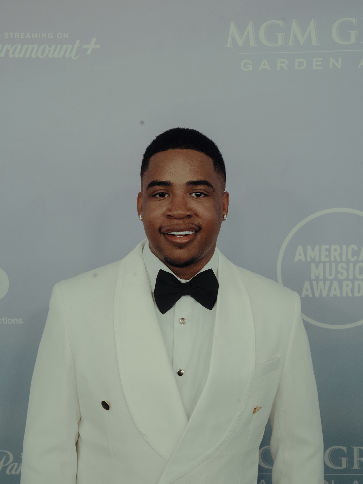 Grammy-nominated producer Turbo The Great in a white tuxedo at the 2026 American Music Awards