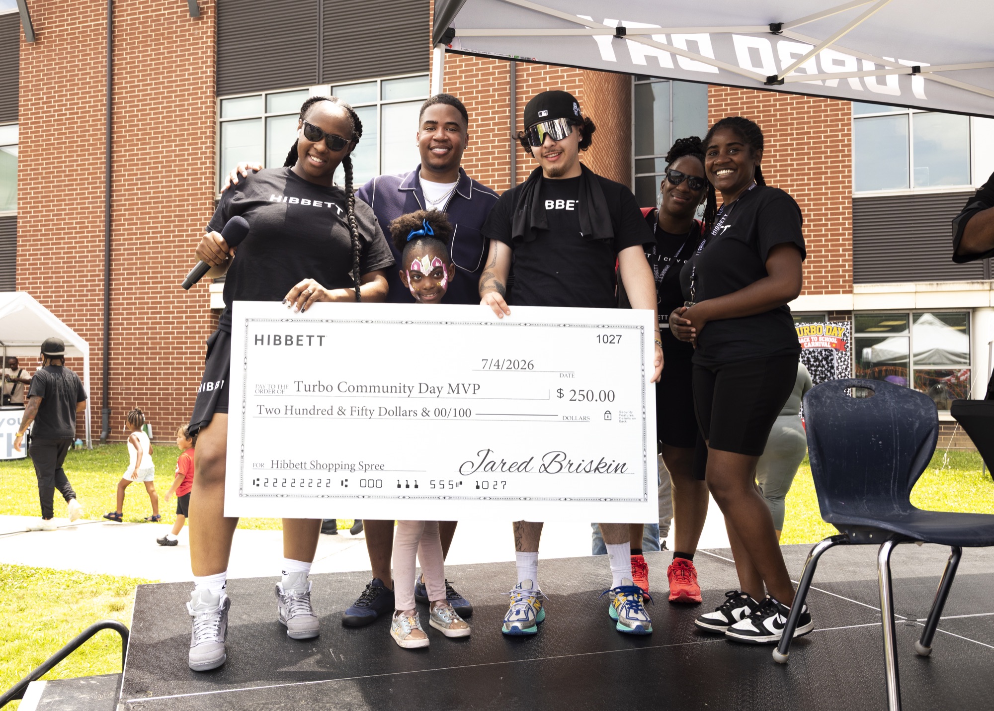 Turbo The Great presents a Hibbett shopping-spree award to a community winner at Turbo Day 2026